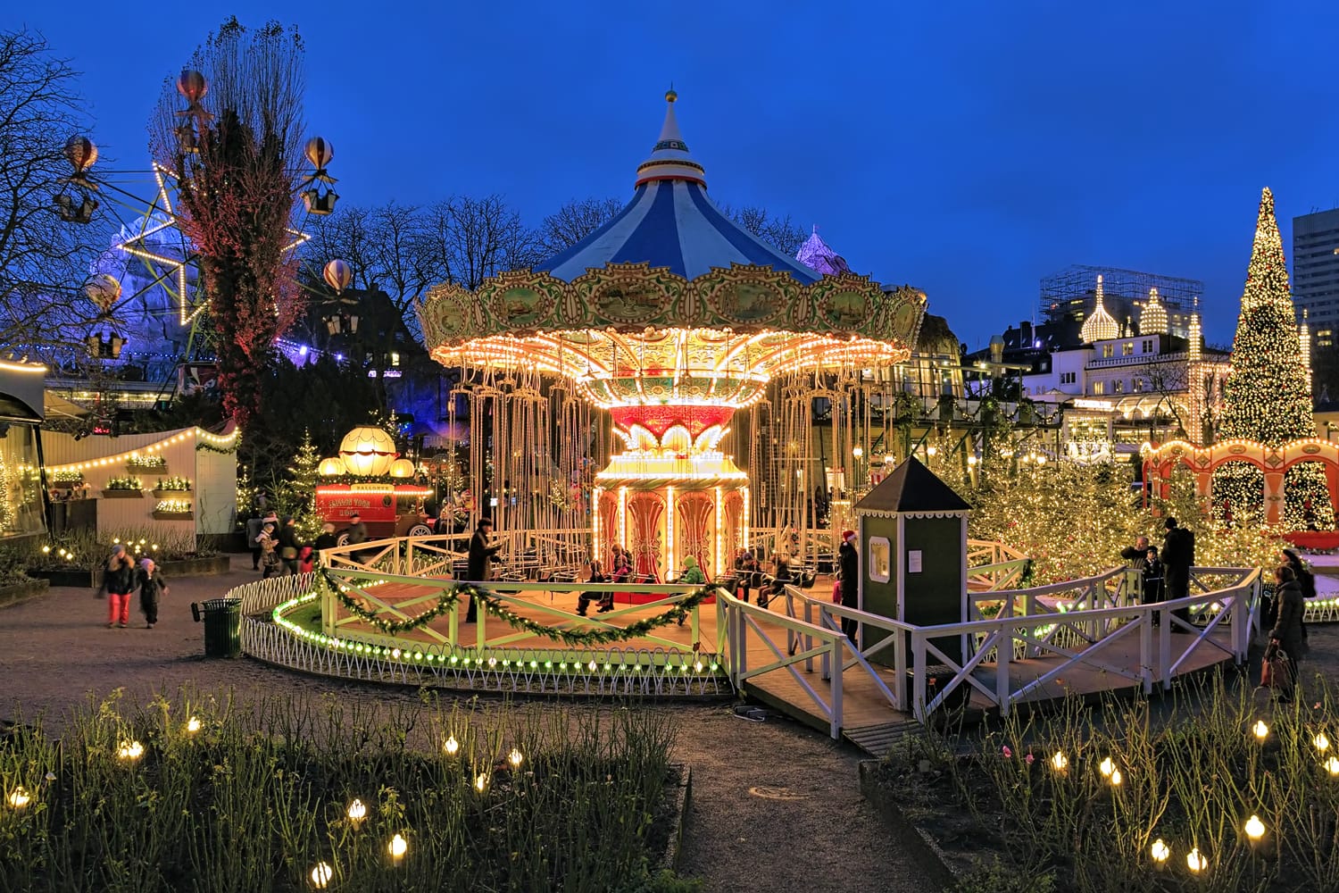La giostra e l'illuminazione natalizia nei Giardini di Tivoli, un famoso parco divertimenti e giardino di piacere a Copenaghen, in Danimarca