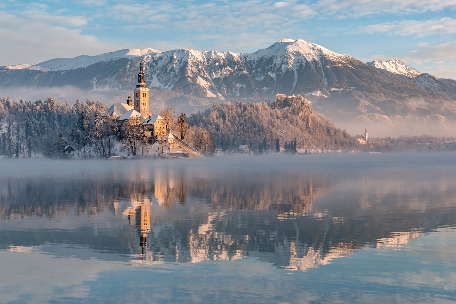 Il lago di Bled con la chiesa e il castello in una tranquilla mattina d'inverno