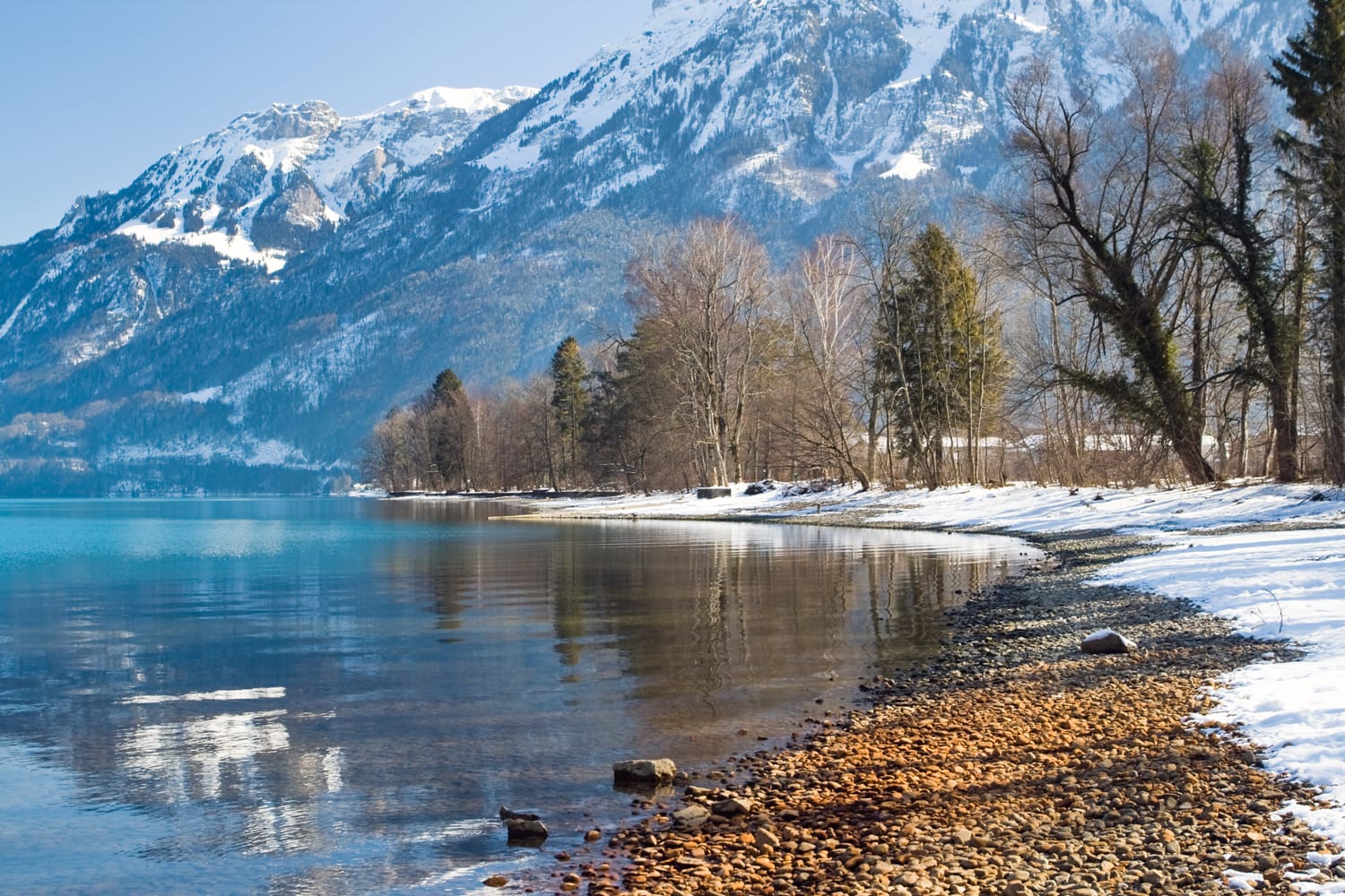 Immagine orizzontale del riflesso del lago sulla riva delle Alpi con uno sfondo blu, Interlaken, Svizzera.